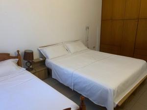 培拉特apartement city center的一间卧室配有两张带白色床单的床