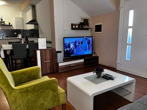 扎达尔Apartment Karma的客厅配有电视、沙发和桌子