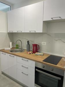 克宁Apartman Stela的厨房配有白色橱柜和水槽