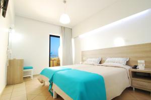 罗希姆诺美杜莎公寓式酒店的一间卧室配有一张带蓝色毯子的大床