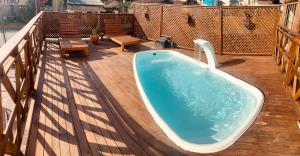佩尼亚Pousada Vila do Cowboy的阳台甲板上的热水浴池