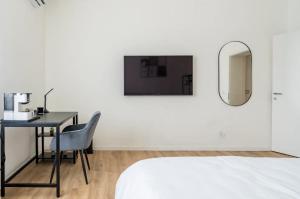 布雷西亚Beno House Brescia的一间卧室配有书桌、一张床和镜子