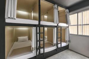 曼谷ORA Hostel Bangkok的客房设有双层床、床和窗户。