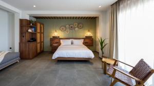 新马尔马拉斯Amyntas Seafront Hotel的一间卧室配有一张床和长凳