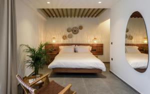 新马尔马拉斯Amyntas Seafront Hotel的一间卧室配有两张床和镜子