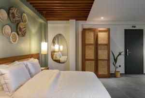 新马尔马拉斯Amyntas Seafront Hotel的卧室配有一张白色大床和镜子