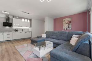 PrievozAir-conditioned 75m2 apartment next to the airport - FREE PARKING的一间带蓝色沙发的客厅和一间厨房
