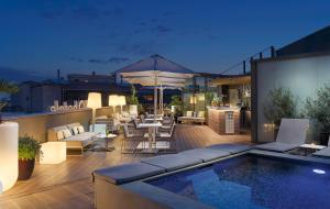 巴塞罗那H10卡萨诺瓦酒店的一个带游泳池和桌椅的屋顶露台
