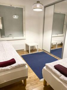 赫尔辛基VUOSAARI-2 Pure luxury for 100 m2 in Vuosaari的一间设有两张床的房间和蓝色地毯