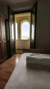 蒙特法尔科AGRITURISMO LA CORTE DEI CAVALIERI的一间卧室设有一张床和一个开放式窗户。