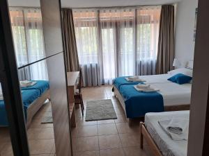 比奥格勒·纳·莫鲁Hotel Albamaris的一间卧室设有两张带蓝色床单和窗户的床。