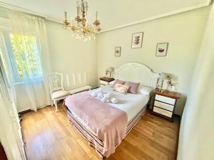 希洪La Casa de la Buganvilla的卧室配有白色的床和吊灯。