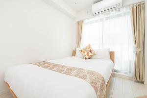东京リアル大久保　Apartment Hotel的白色的卧室设有床和窗户