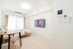 东京リアル大久保　Apartment Hotel的白色的客房配有床、桌子和书桌