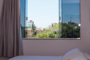 佩尼亚HN-Hotel Natal Penha的一间卧室设有窗户,享有城市美景