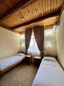 撒马尔罕卡文赛瑞酒店的客房设有两张床和窗户。