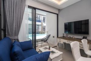 苏林海滩Palmyrah Surin Beach Residence的客厅配有蓝色的沙发和电视
