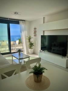 林孔-德拉维多利亚Rincón Idilia (Málaga).的一间带大电视的客厅和一间享有海景的客厅