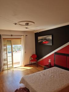 费拉古多Serra e Mar Ferragudo的一间卧室配有一张床和一张红色椅子