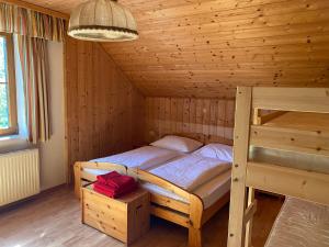 LassingBauernhof Plachl的木制客房内的一间卧室,配有一张床
