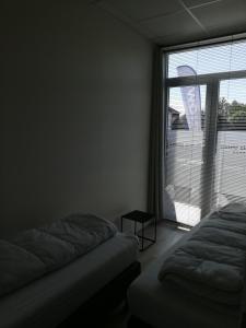 ZottegemNuvola ULTIMO Resort的一间卧室设有两张床和大窗户
