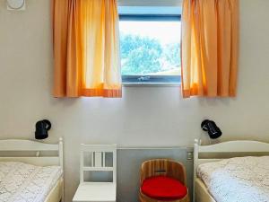 乌德瓦拉Holiday home UDDEVALLA XXXVI的客房设有两张床和一个带橙色窗帘的窗户。