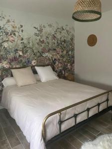 BillèreZénitude et proximité的一间卧室配有一张带花卉壁纸的床