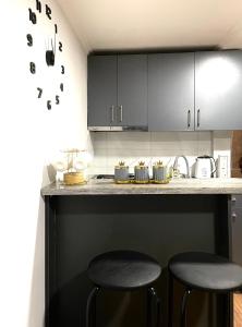 第比利斯View Corner的厨房配有黑色橱柜和2张凳子。