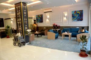 艾卜哈فندق فربيون ابها - Ferbion Hotel Abha的大堂设有带蓝色沙发和桌子的等候室