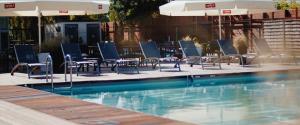 弗瓦迪斯瓦沃沃Maloves Resort & Spa的一个带桌椅和遮阳伞的游泳池