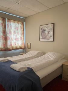 AskAskvoll Fjordhotell的一间卧室设有两张床和窗户。