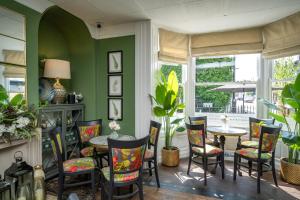 ChatterisThe Bramley House Hotel的一间拥有绿色墙壁和桌椅的用餐室