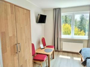 哈茨山区黑尔茨贝格AM BERG Hotel的配有桌子和两把椅子及一张床的房间