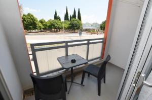 罗维尼Miro Apartment的阳台配有桌椅,享有街道的景色。