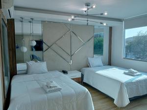 特鲁希略Wyka Hotel的一间卧室配有两张带毛巾的床