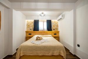 古维亚Mathraki Resort的一间卧室,配有一张床,上面有帽子