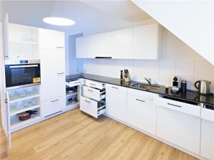 埃申茨Exklusive 4.5 Zimmer Wohnung für Familien und Business的白色的厨房配有白色橱柜和木地板