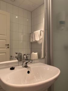 AskAskvoll Fjordhotell的浴室水槽设有水龙头和镜子