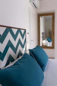 索伦托Relais del Mare的一间卧室配有一张带蓝色枕头和镜子的床