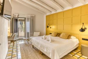 帕劳·萨巴尔德拉Mas Cusi的卧室配有白色的床和黄色的墙壁