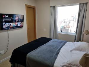 圣保罗Apartamento Vista Maravilhosa - Próximo da Paulista的卧室配有一张床,墙上配有电视。