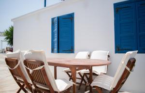 纳克索斯岛卡斯特拉基Aeraki Studios的一张木桌和椅子,拥有蓝色的门和窗户