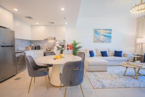 迪拜Nasma Luxury Stays - Fancy Apartment With Balcony Close To MJL's Souk的厨房以及带桌椅的起居室。