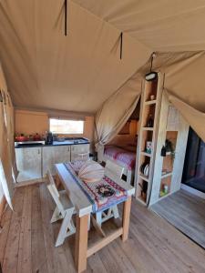 帕尔马迪蒙泰基亚罗Tendu' Punta Bianca Glamping Camp的帐篷内带桌子和床的房间