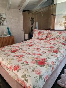 帕尔马迪蒙泰基亚罗Tendu' Punta Bianca Glamping Camp的卧室内一张带花卉棉被的床