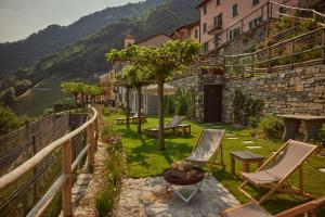 Scudellate"La Casa dei Gelsi" - Panorama Lodge MONTE GENEROSO的享有带椅子的花园和大楼的景色