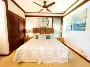 科洛阿KP40 1Br Poipu Corner Condo with AC, Steps to the Beach的卧室配有白色的床和吊扇