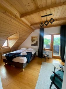什切尔克Michałówka na Kubalowej Łące的一间带一张大床的卧室,位于一个拥有木制天花板的房间