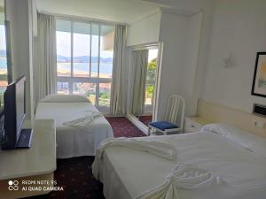 拉雷多Hotel Miramar Laredo的酒店客房设有两张床和大窗户。