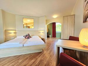 TrebesingFamilienhotel Trebesingerhof的配有一张床和一张书桌的酒店客房